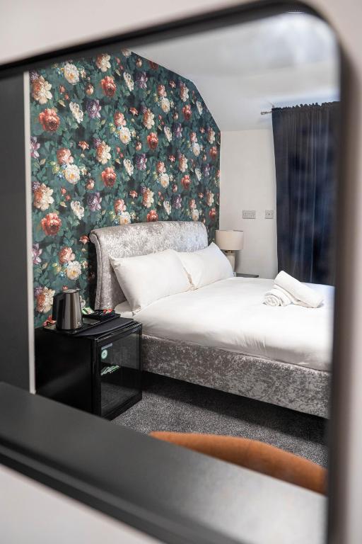 a bedroom with a bed with a floral wall at Norfolk Park Rooms - Sheffield City in Sheffield