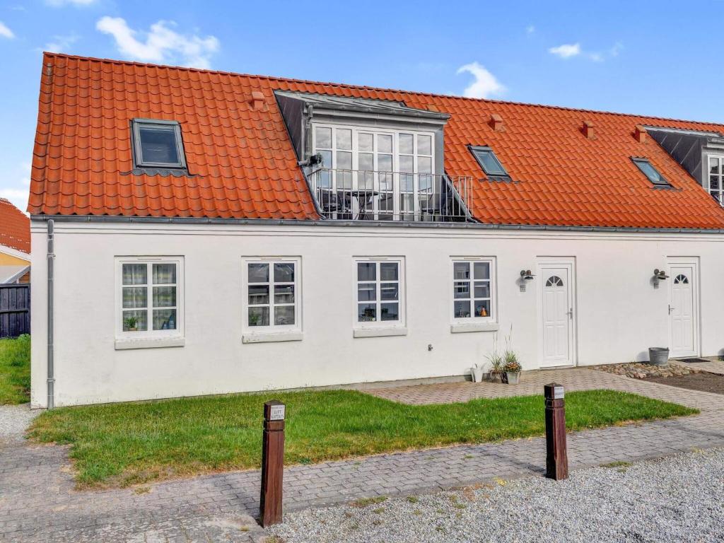 ein weißes Haus mit einem orangefarbenen Dach in der Unterkunft Cozy Retreat in Lokken - By Traum Ferienwohnungen in Løkken