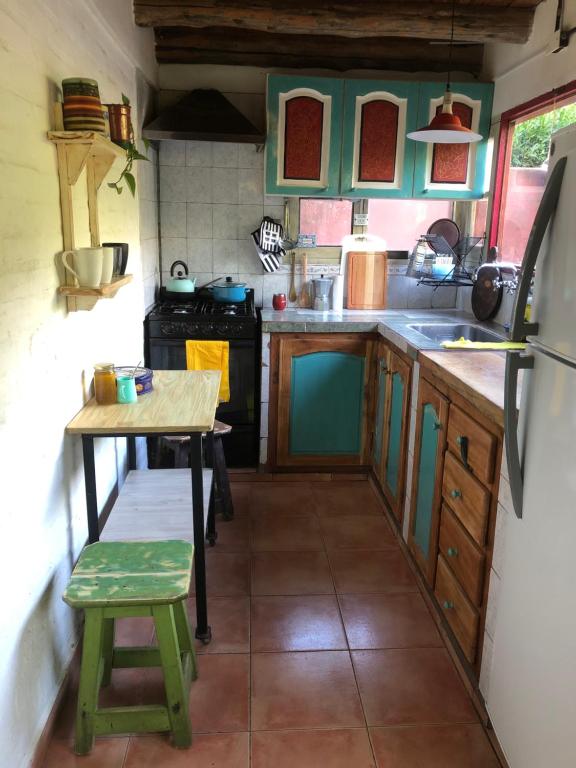a small kitchen with a table and a stove at Lugar bonito casa de dos habitaciones in El Bolsón