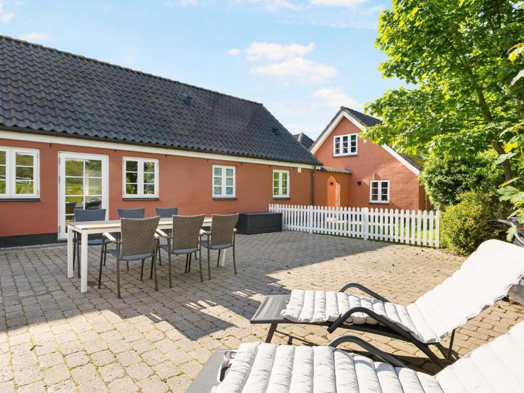 eine Terrasse mit Stühlen, einem Tisch und einem Haus in der Unterkunft Charming Seaside Escape - By Traum Ferienwohnungen in Hjørring