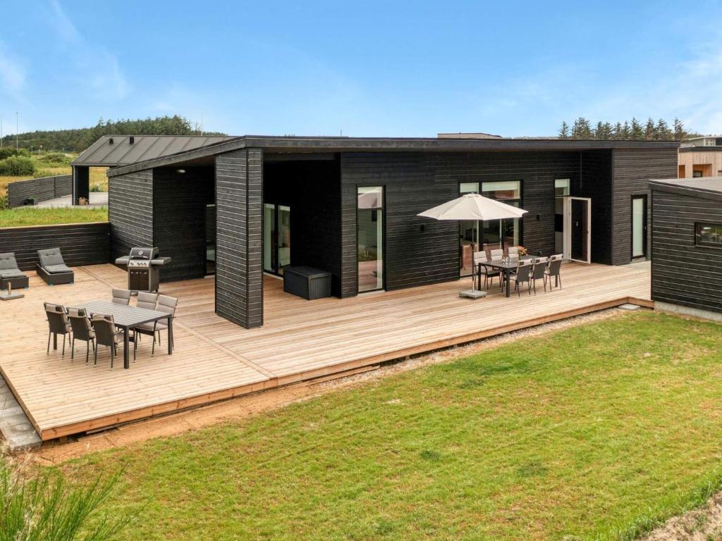 a house with a wooden deck with a table and chairs at Luxury Retreat in Lokken - By Traum Ferienwohnungen in Løkken