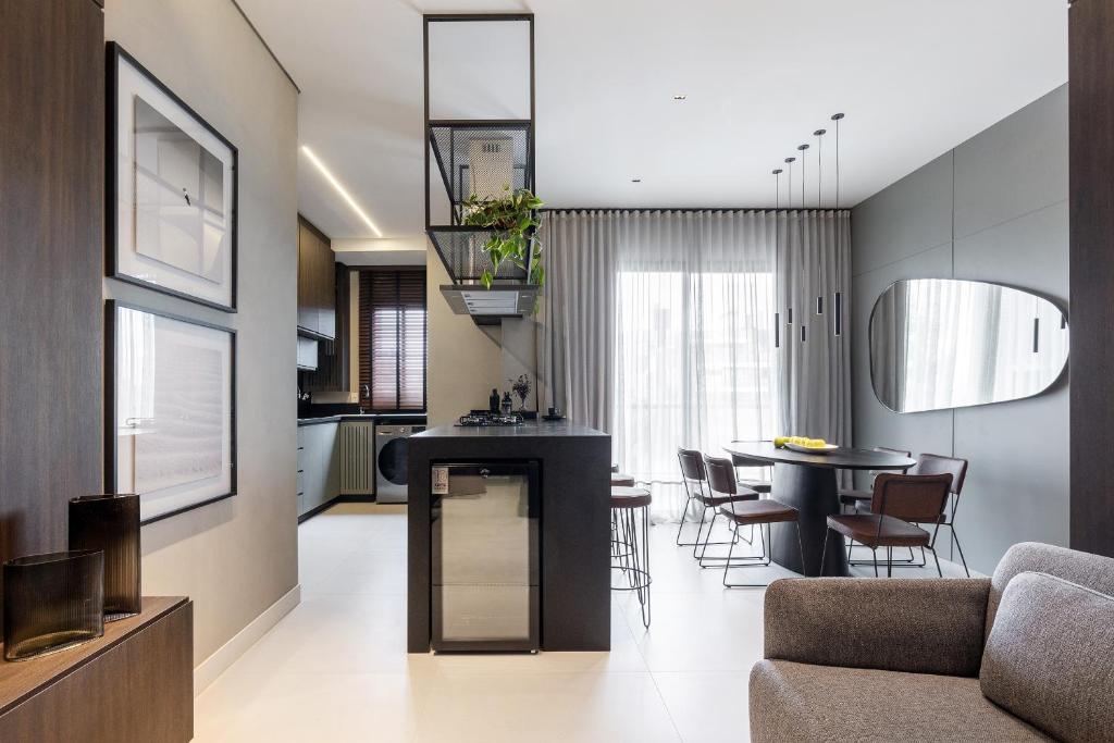 a kitchen and living room with a table and chairs at Apto novo e confortável em Canto Grande, Bombinhas in Bombinhas