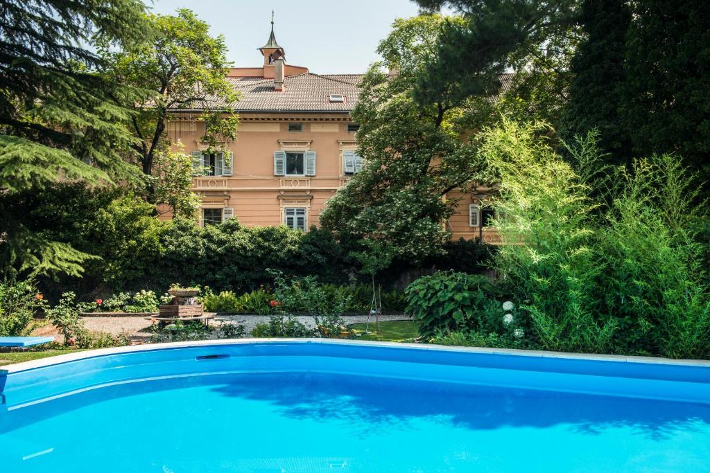 a large blue swimming pool in front of a building at Hotel Elephant in Bressanone