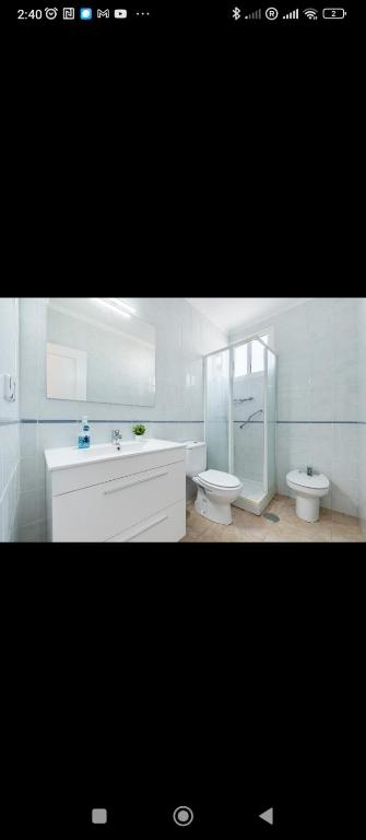 a white bathroom with a sink and a toilet at Torrebeach in Torre de la Horadada