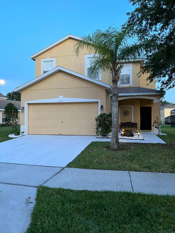 a house with a palm tree in front of it at Cozy Villa With South Facing Pool in Davenport