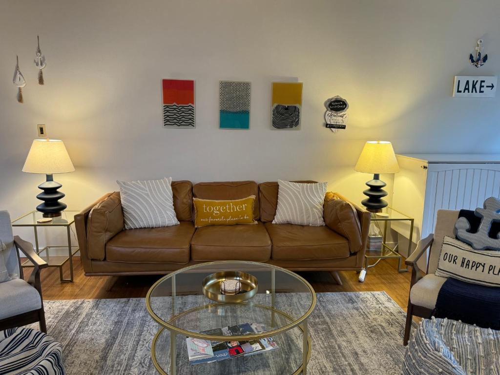 a living room with a couch and a glass table at Newly Remodeled Mid-Century Modern Lake Condo in Lake Geneva
