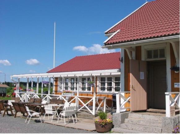 a building with chairs and tables in front of it at Ilola Maatilamatkailu in Valkeakoski