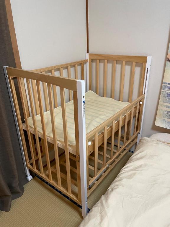 高松市にあるINARI - Vacation STAY 87349のベッドの横の部屋のベビーベッド