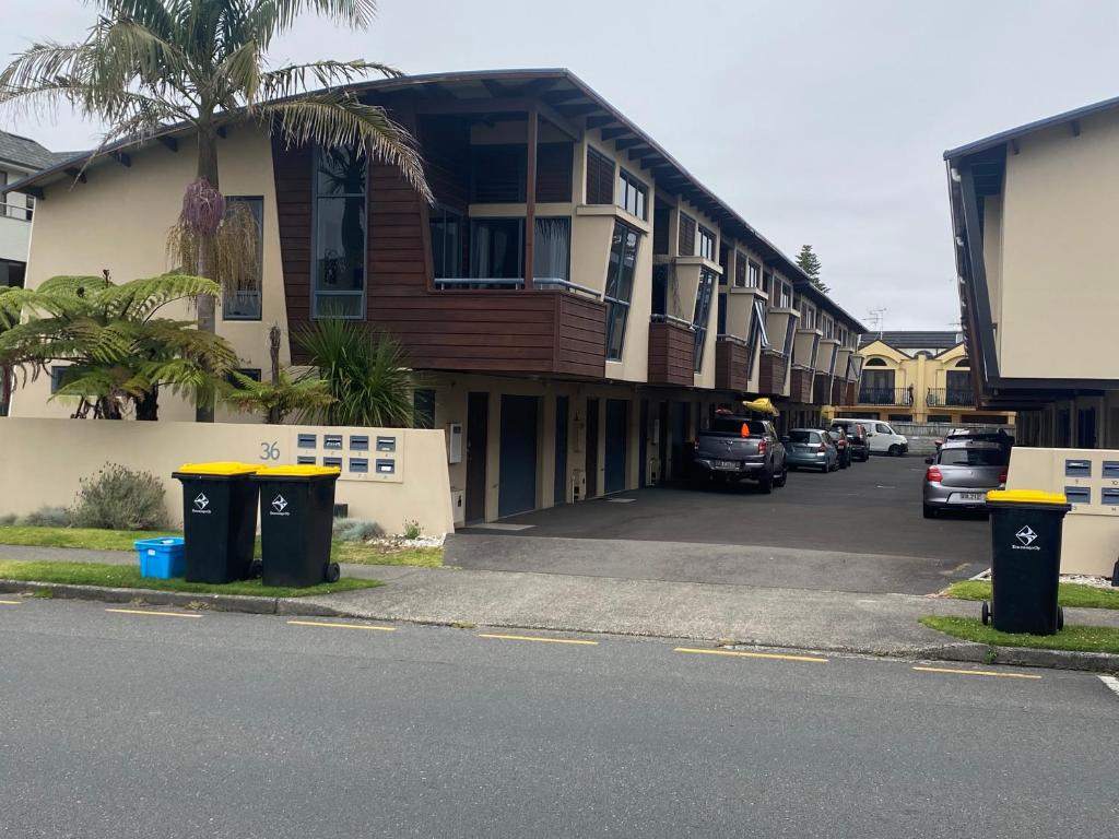 a parking lot with cars parked in front of a building at Beach Break in Mount Maunganui