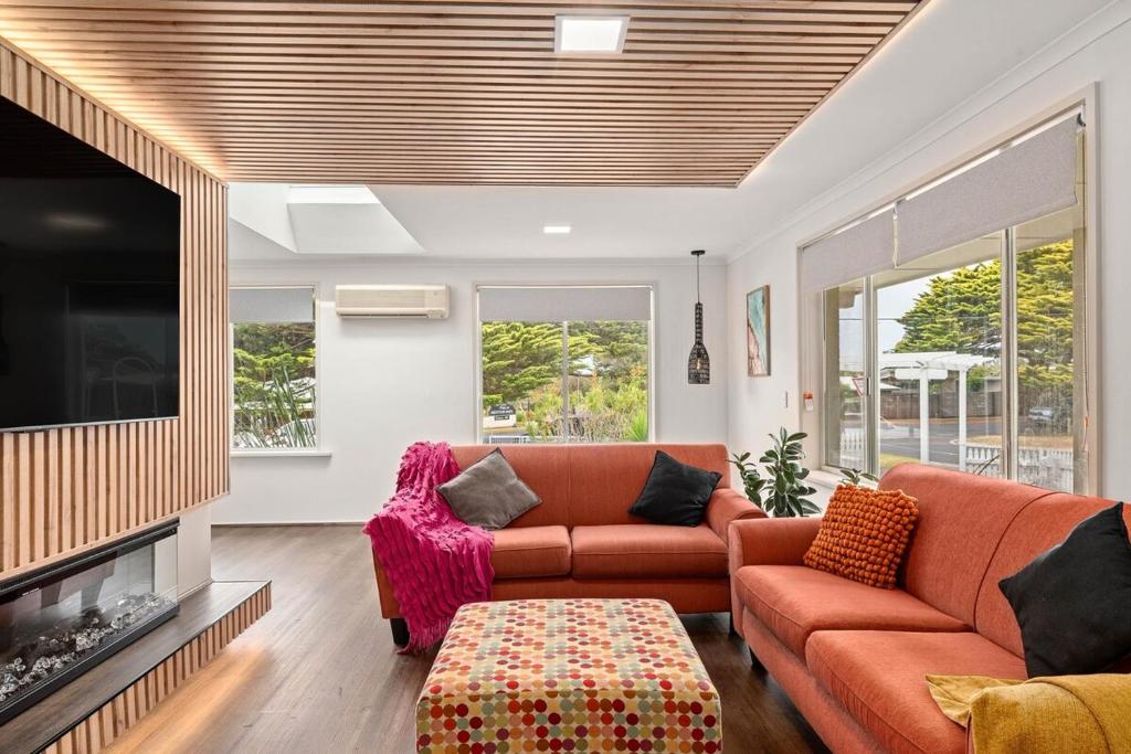 卡尔斯The Green Garden Gate - Phillip Island的客厅里有一张沙发和一台电视