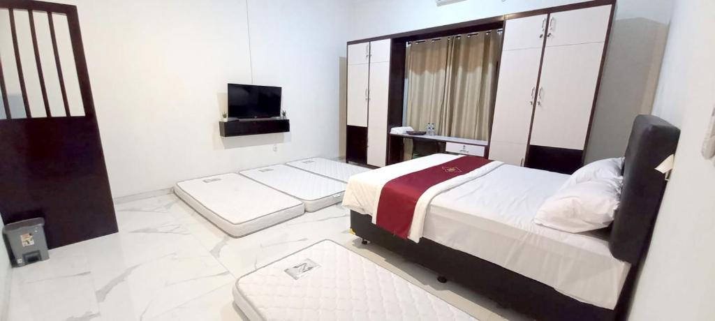 um pequeno quarto com uma cama e uma televisão em Griya Ngasem Djogja em Yogyakarta