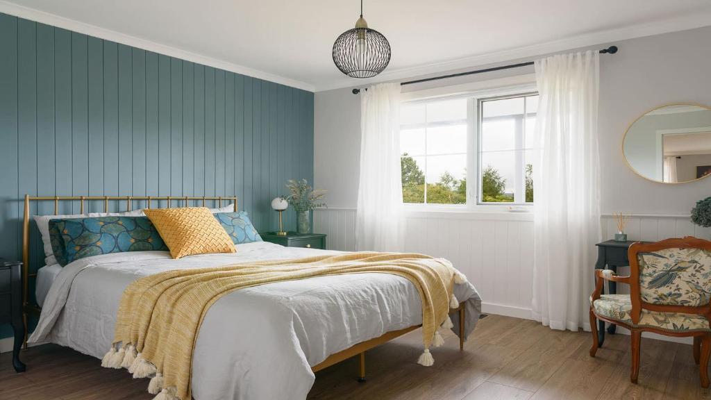 a bedroom with a bed and a window and a chair at Grenville Belle Daylesford in Daylesford