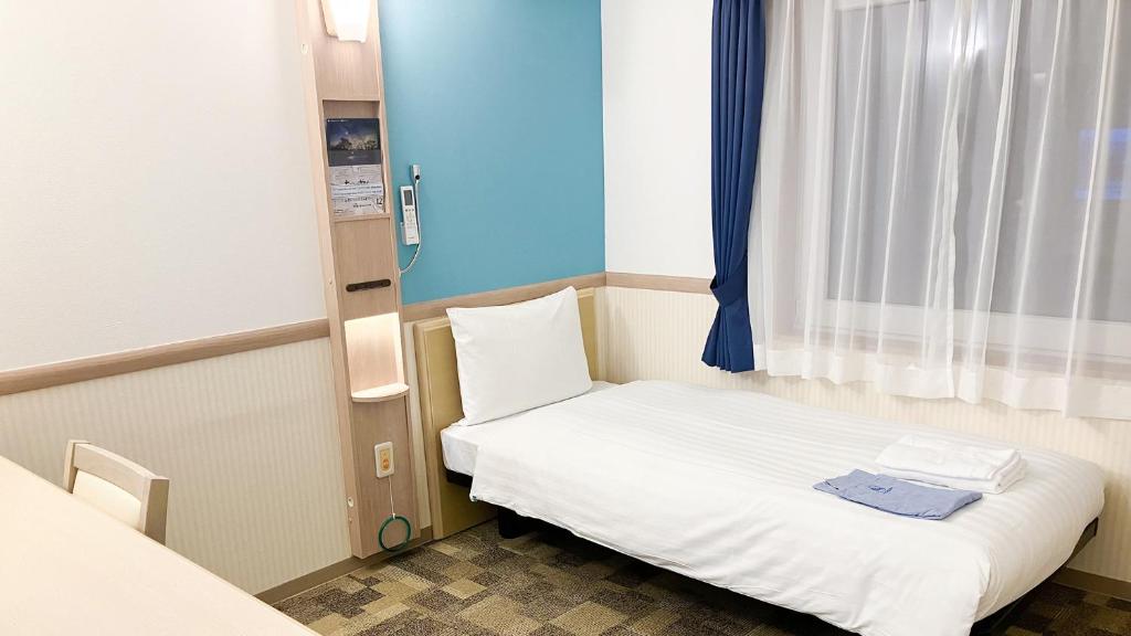 Postel nebo postele na pokoji v ubytování Toyoko Inn Iseshi Eki
