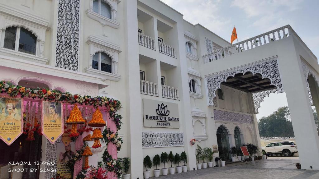 un edificio bianco con un cancello e dei fiori di raghukul sadan a Faizābād