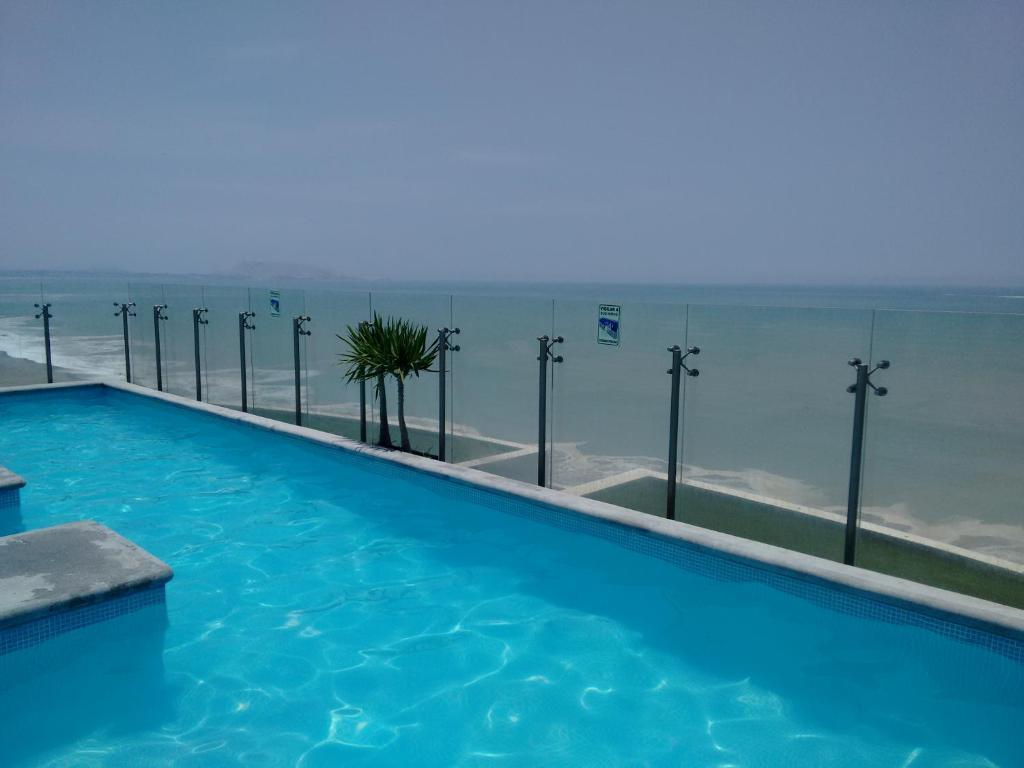 a swimming pool with the ocean in the background at Ocean View Beautiful Aparment in Lima