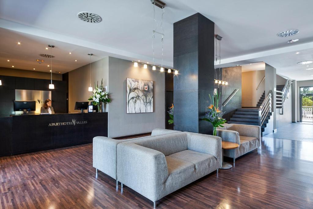 eine Lobby mit Sofas und einer Theke in einem Gebäude in der Unterkunft Aparthotel Attica 21 Vallés in Sabadell