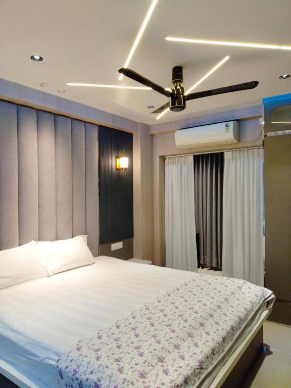 a bedroom with a bed with a ceiling fan at JRF Hotel in kolkata