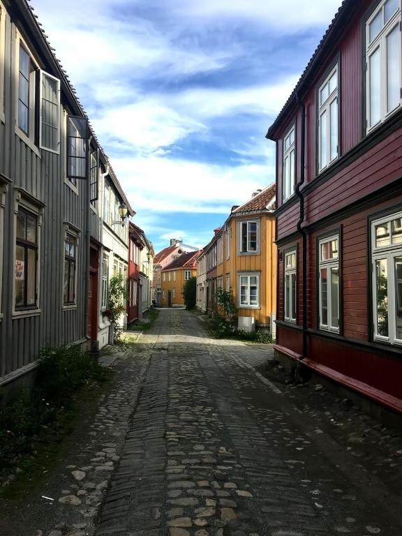 an empty street in a town with wooden houses at Liten studioleilighet meget sentralt i sentrum, 3 minutter fra torget in Trondheim