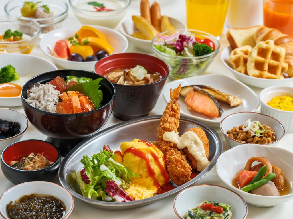 a table topped with bowls of different types of food at Dormy Inn Kanazawa Natural Hot Spring in Kanazawa