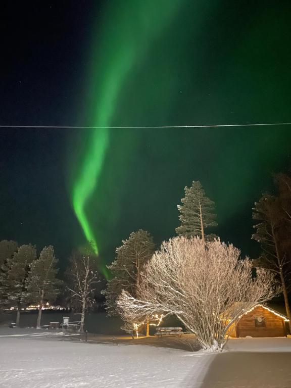 una imagen de la aurora en el cielo en Napapiirin Eräkartano, en Pello
