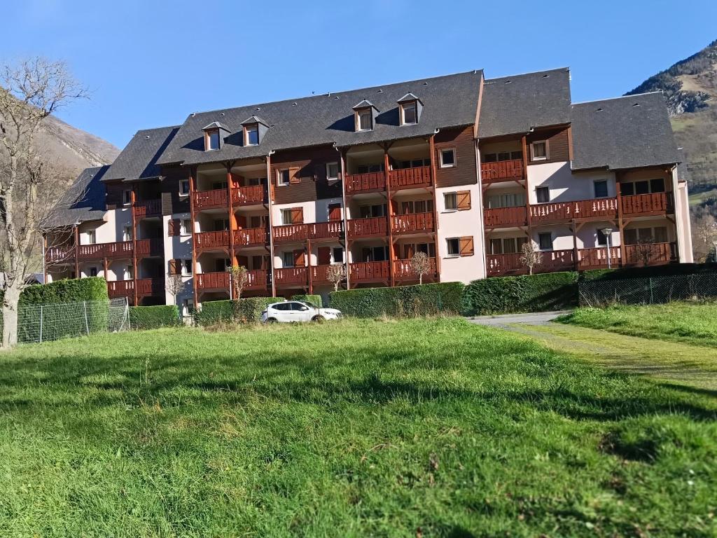 a large apartment building with a car parked in front at LUZVAL Duplex avec Balcon in Luz-Saint-Sauveur