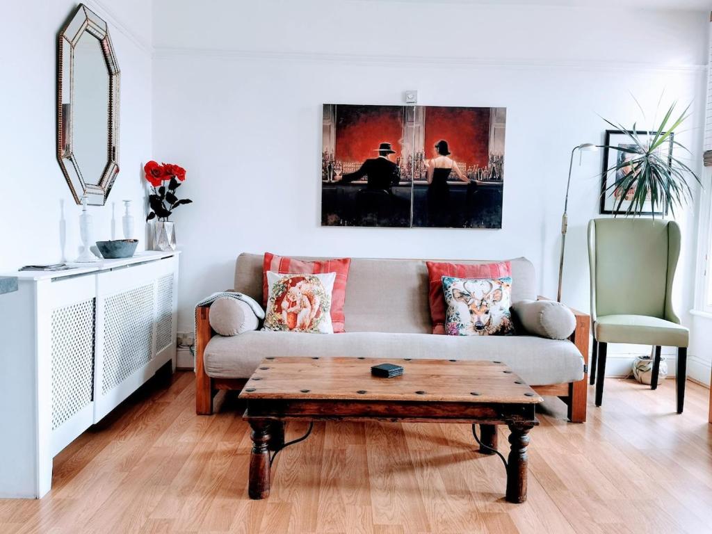 Una sala de estar con un sofá y una mesa de café. en Victoriana Duplex Apartment, en Stratford-upon-Avon