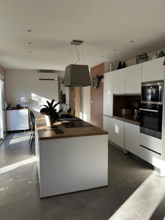 - une cuisine avec un îlot blanc dans une chambre dans l'établissement Maison la Cocagne de la Sainte Baume, à Nans-les-Pins