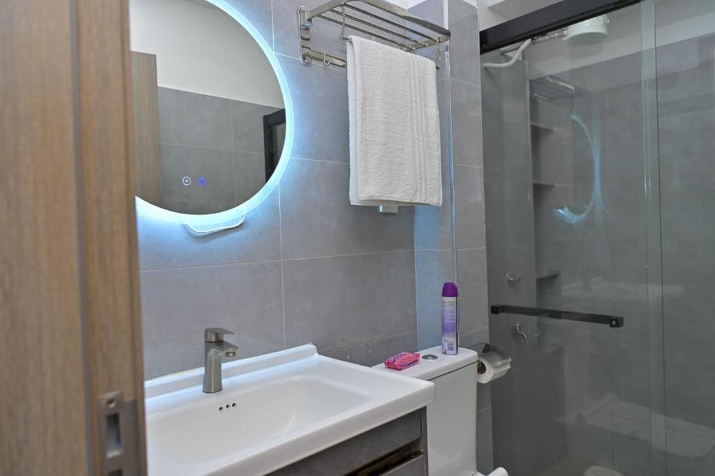 a bathroom with a sink and a mirror and a toilet at Nicestay Homes in Nairobi