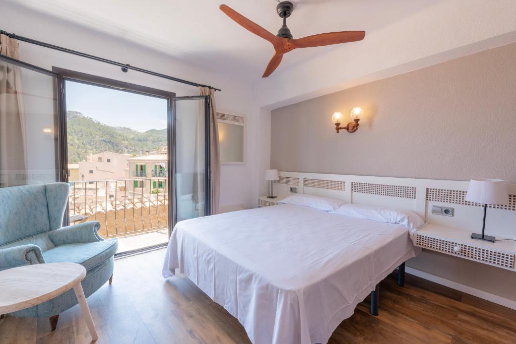 een slaapkamer met een bed en een plafondventilator bij Hostal Sa Baronia in Banyalbufar