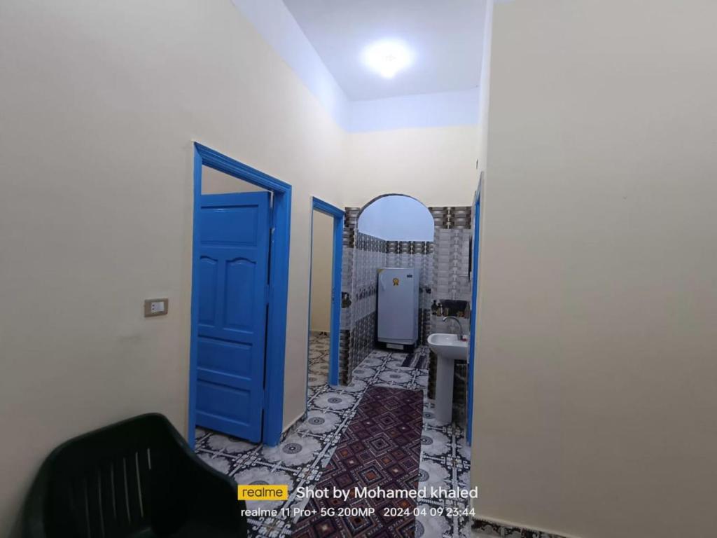 a bathroom with a blue door and a sink at Amoun أمون in Siwa