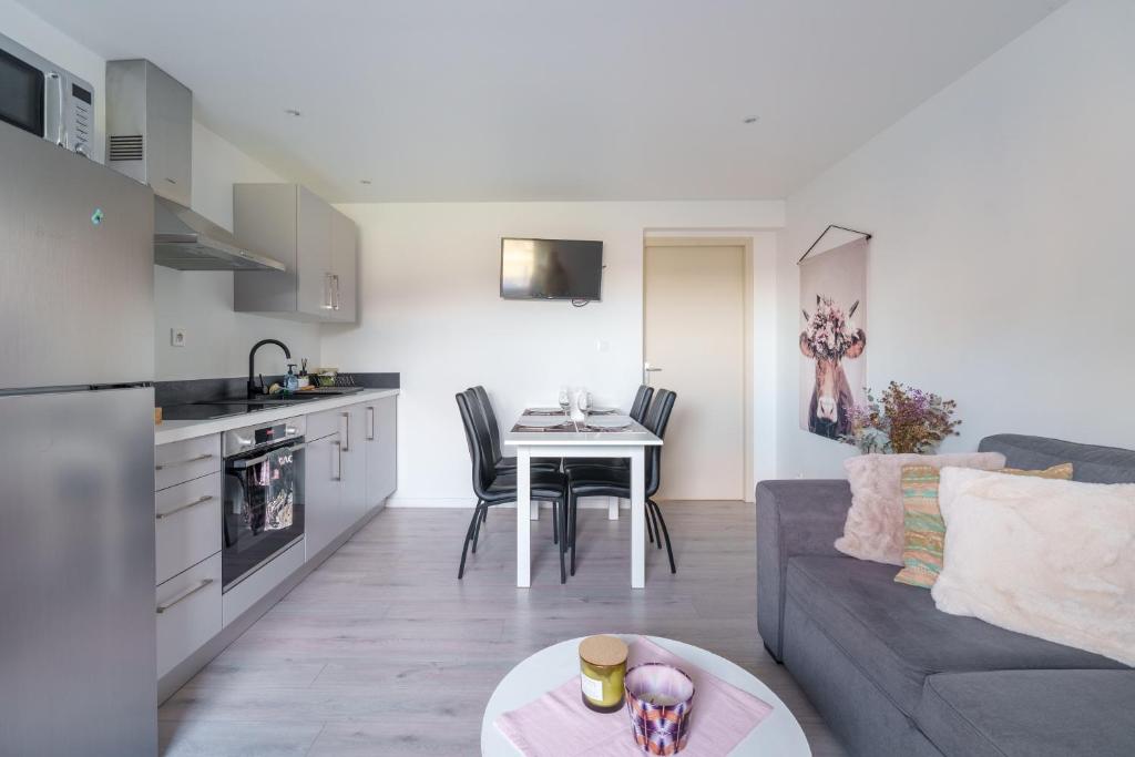 une cuisine et un salon avec un canapé et une table dans l'établissement Le Cafranc - Appt en pleine nature, à Le Tholy