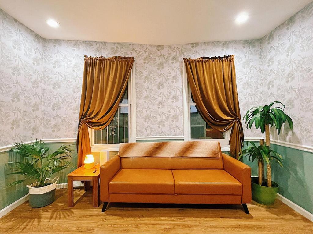 a living room with a couch and two windows at 3 bdrm stay! Trippy King Suite by Dwtwn Nwk in Newark
