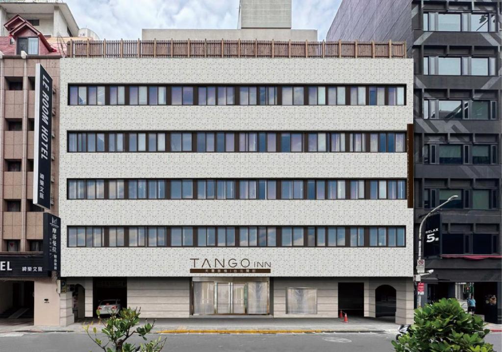 un grande edificio bianco con un cartello sopra di Tango Inn Taipei Kaifong a Taipei