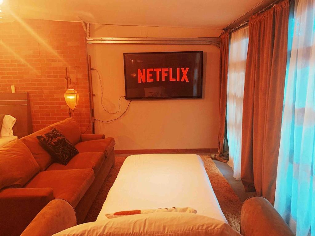 a living room with a couch and a tv at BRICK CITY VILLA! 20 minutes from NYC in Newark