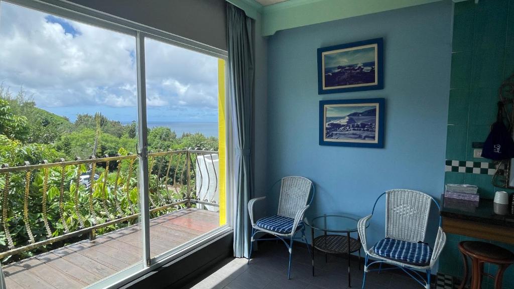 a room with two chairs and a balcony with a view at Nanwan Haiye Villa in Hengchun