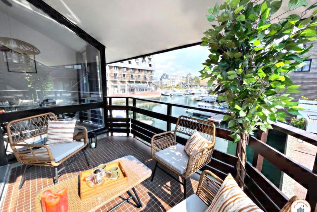 d'un balcon avec des chaises, une table et un arbre. dans l'établissement Temps des Cerises - Terrasse - Plage - Marina, à Deauville