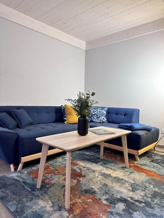 a living room with a blue couch and a coffee table at Ferienhaus rausZeit in Dernau