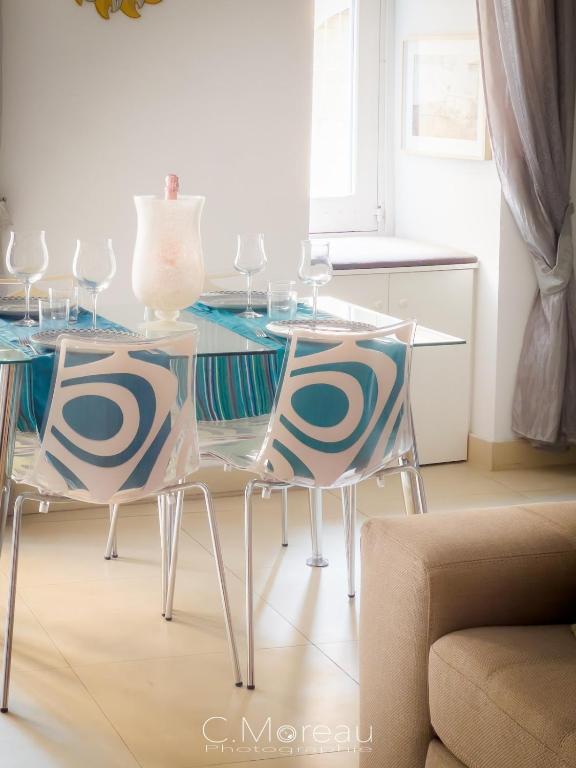 a glass table with two chairs and a table with wine glasses at Valletta Charming 2 Bedroom Apt in Valletta
