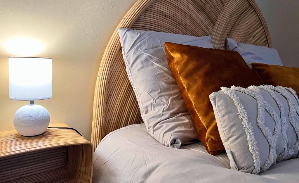 een bed met een houten hoofdeinde naast een lamp bij NID D'OPALE - Le Portel in Le Portel