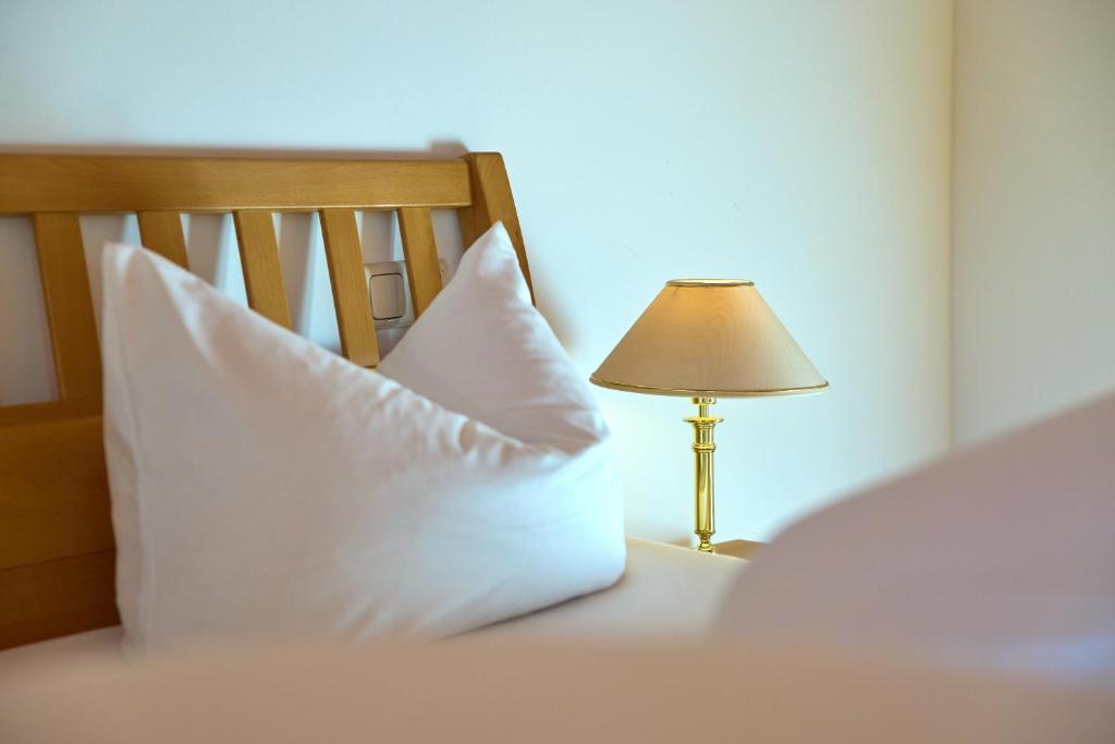a bed with two pillows and a lamp on it at Litz Lounge Apartments by Pferd auf Wolke in Schruns-Tschagguns