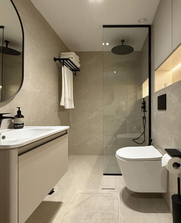 a bathroom with a toilet and a sink and a shower at Signature Studio JLT in Dubai