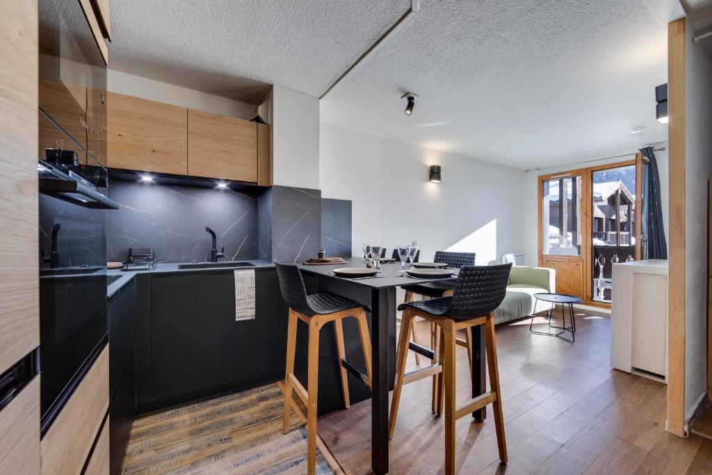 a kitchen with a table and chairs in a room at Jardins de Val Le charme à la Montagne in Val dʼIsère