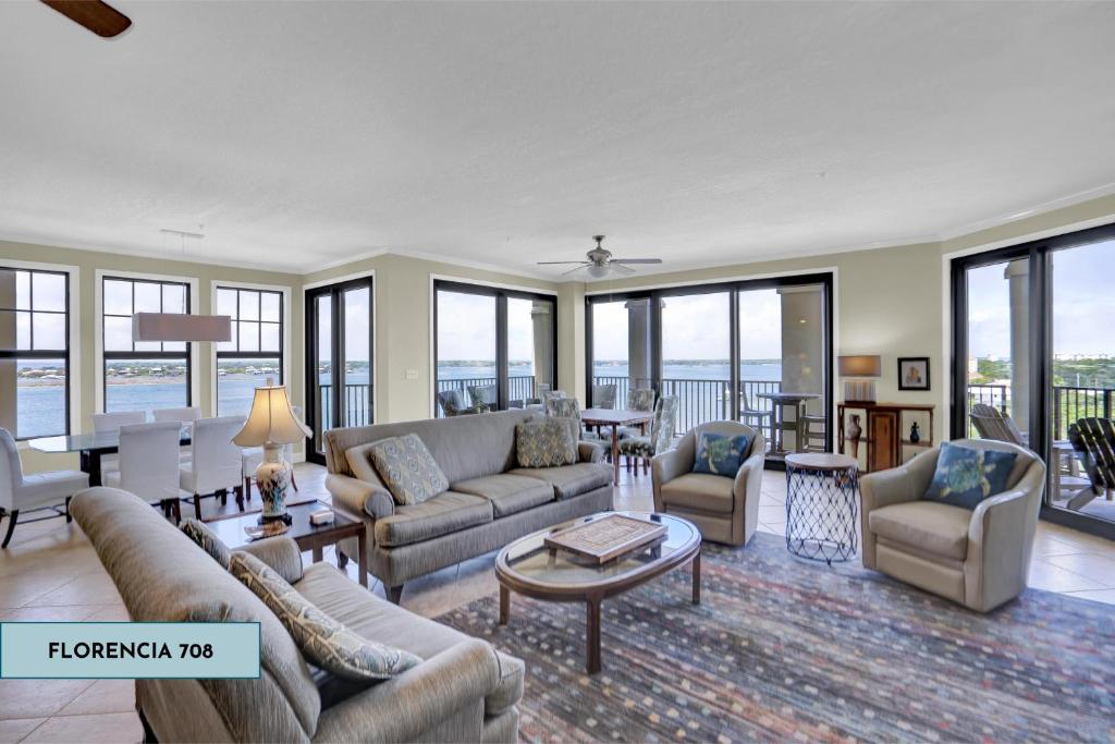a living room with couches and tables and windows at Florencia 708 by Liquid Life in Pensacola