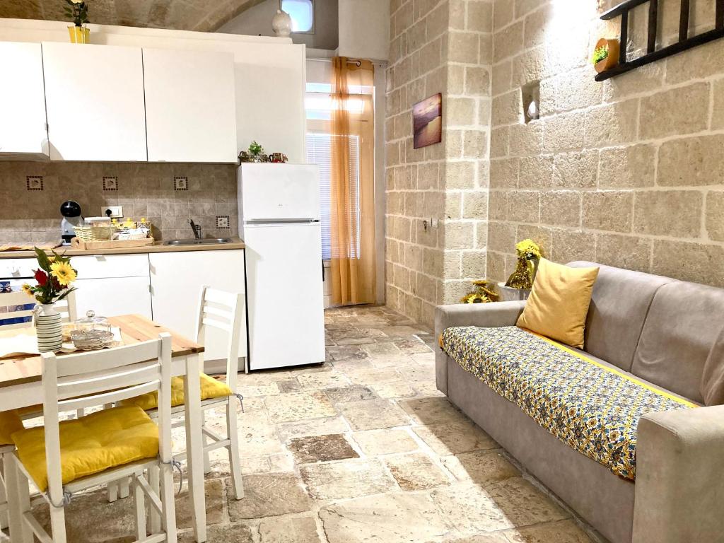 a kitchen and a living room with a couch and a table at Antica Pietra in Polignano a Mare