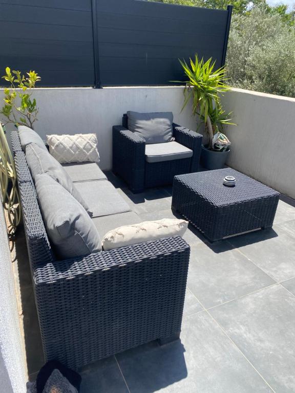 d'une terrasse avec un canapé, des chaises et une table. dans l'établissement Appartement moderne et cosy, à Marseille