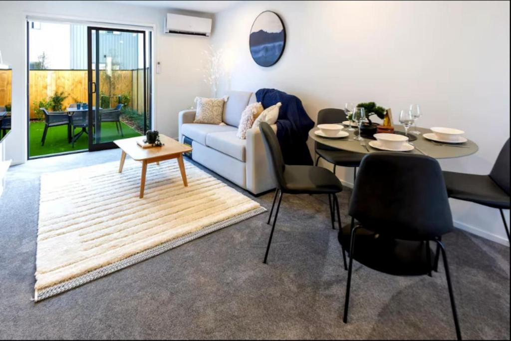 un salon avec un canapé et une table dans l'établissement Lovely 2 bed 2 bath, à Christchurch