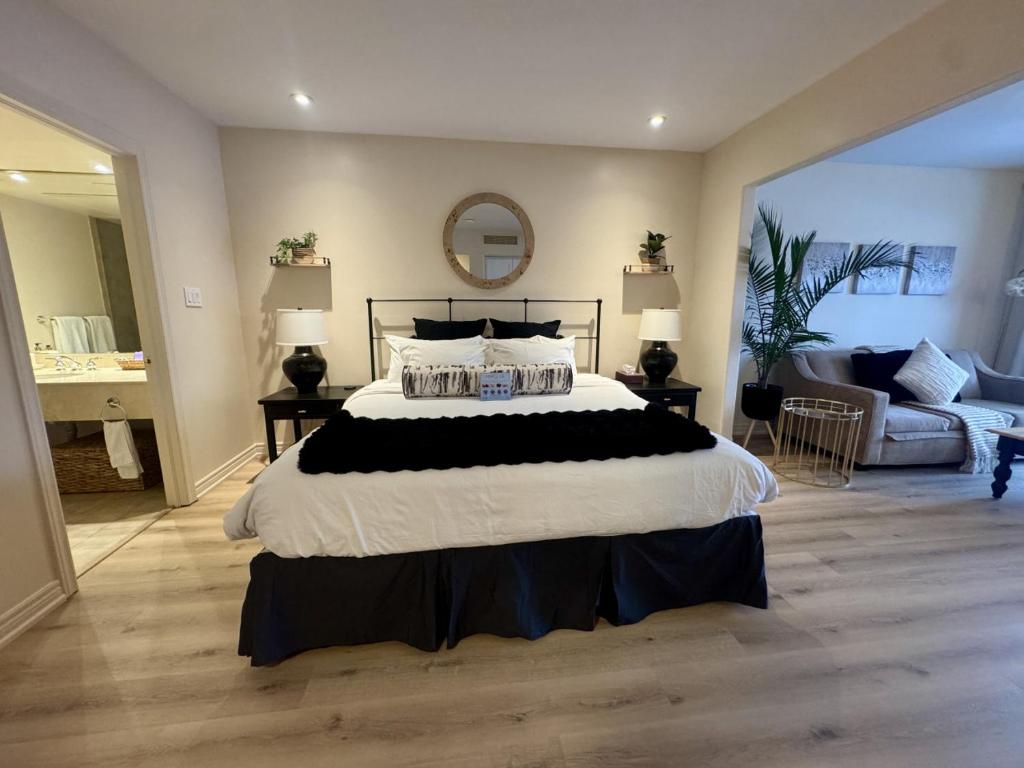 a bedroom with a large bed and a living room at Newly Renovated Ski-In Ski-Out 1-Bedroom Condo with Pool, Gym, Sauna by Horseshoe Valley in Edgar