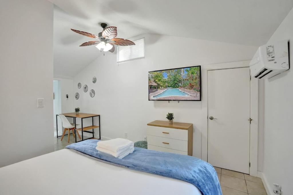 a bedroom with a bed and a tv on the wall at Tropical Oasis Studio w Pool in Fort Lauderdale