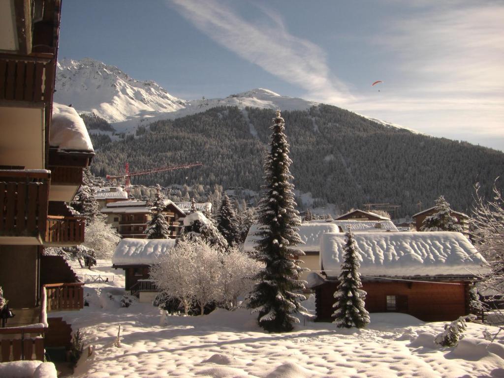 un pueblo cubierto de nieve con árboles y una montaña en Sportrama 115 en Verbier
