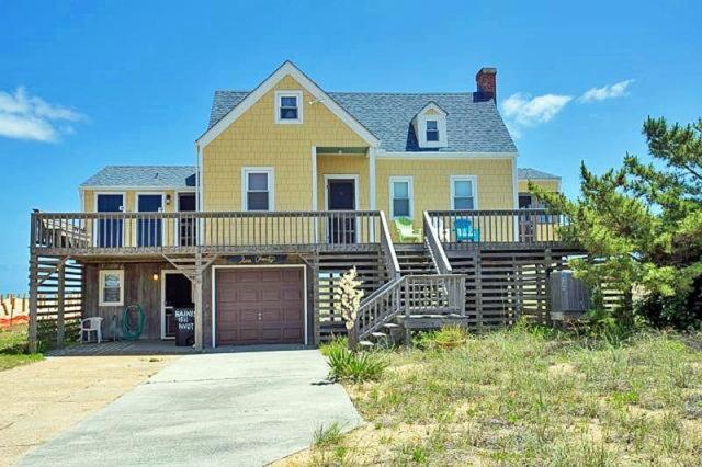 a large yellow house with a large deck at KD1511- Sea Chanty in Kill Devil Hills